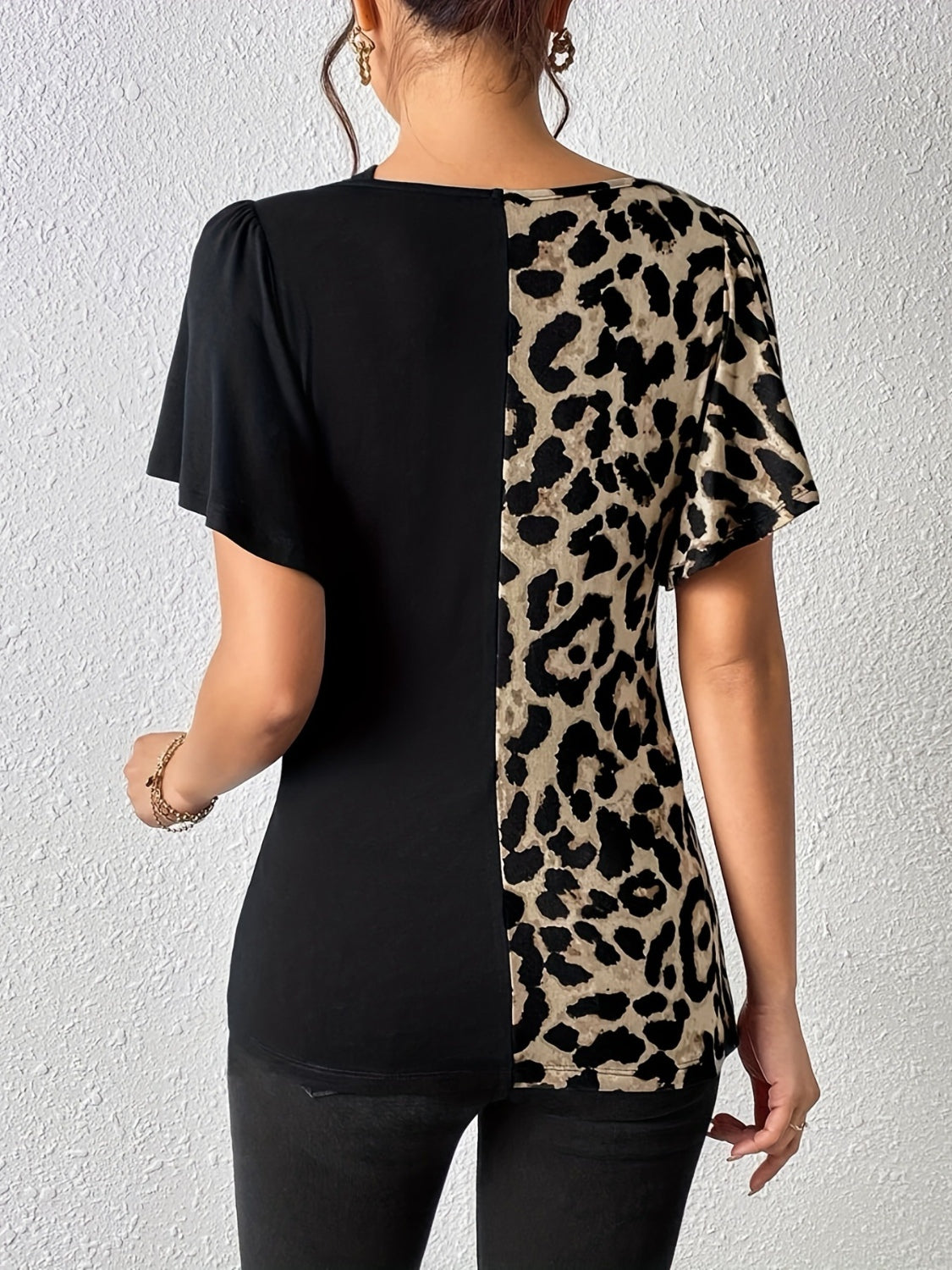 Black and leopard print asymmetric paneled top with short sleeves.