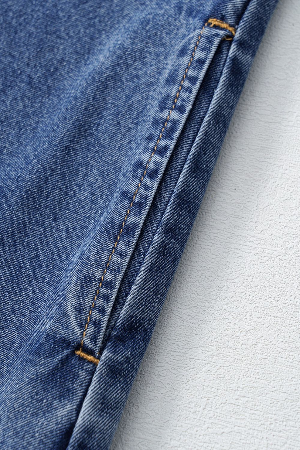 Light blue denim mini dress with visible pocket detail and contrast stitching.