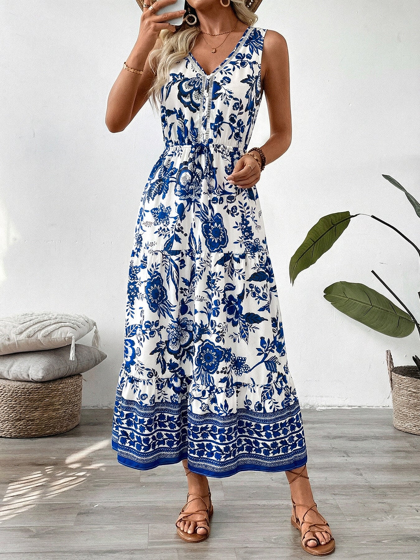 Charming floral midi dress with drawstring waist, V-neck, sleeveless, tiered hem, blue and white pattern.