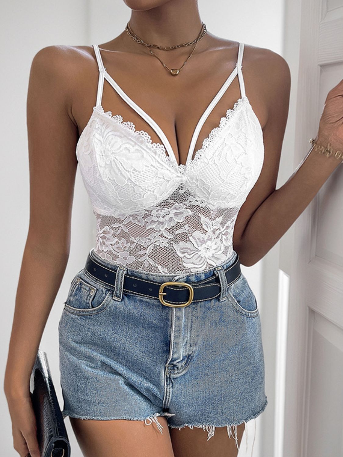 White floral lace crossover bodysuit with strappy neckline and scalloped trim