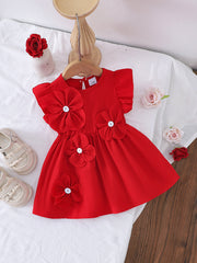 Red cotton baby dress with ruffle sleeves and large flower appliqués.