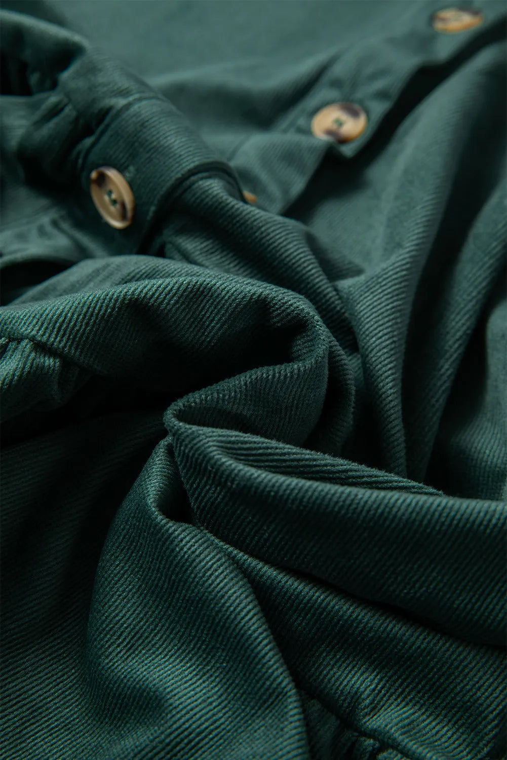 Dark green corduroy button-up blouse with textured fabric and visible buttons.