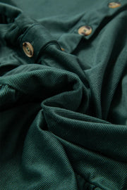 Dark green corduroy button-up blouse with textured fabric and visible buttons.