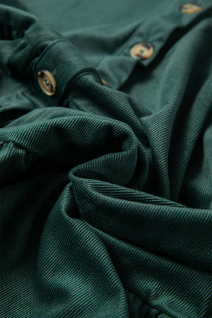 Dark green corduroy button-up blouse with textured fabric and visible buttons.