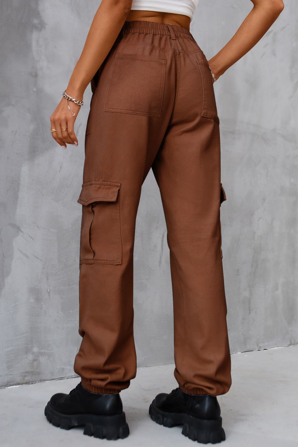 Brown utility cargo trousers with elasticated cuffs and multiple pockets.