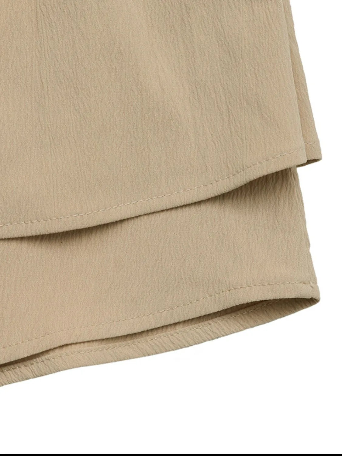 Tiered ruffle mini skirt in tan with textured fabric and visible stitching detail.