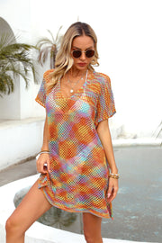 Open-knit caftan with V-neck, short sleeves, and a slit hem in a colorful rainbow pattern.