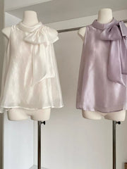 Sleeveless shirt with large bow detail in purple and white.
