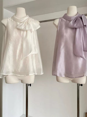 Sleeveless shirt with large bow detail in purple and white.