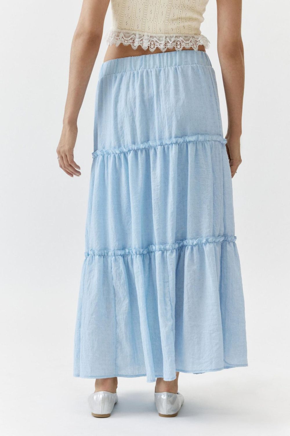 Tiered cotton maxi skirt in light blue with ruffled tiers and an elastic waistband.