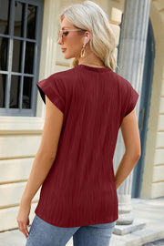 Burgundy textured cap sleeve top with a mock neckline.