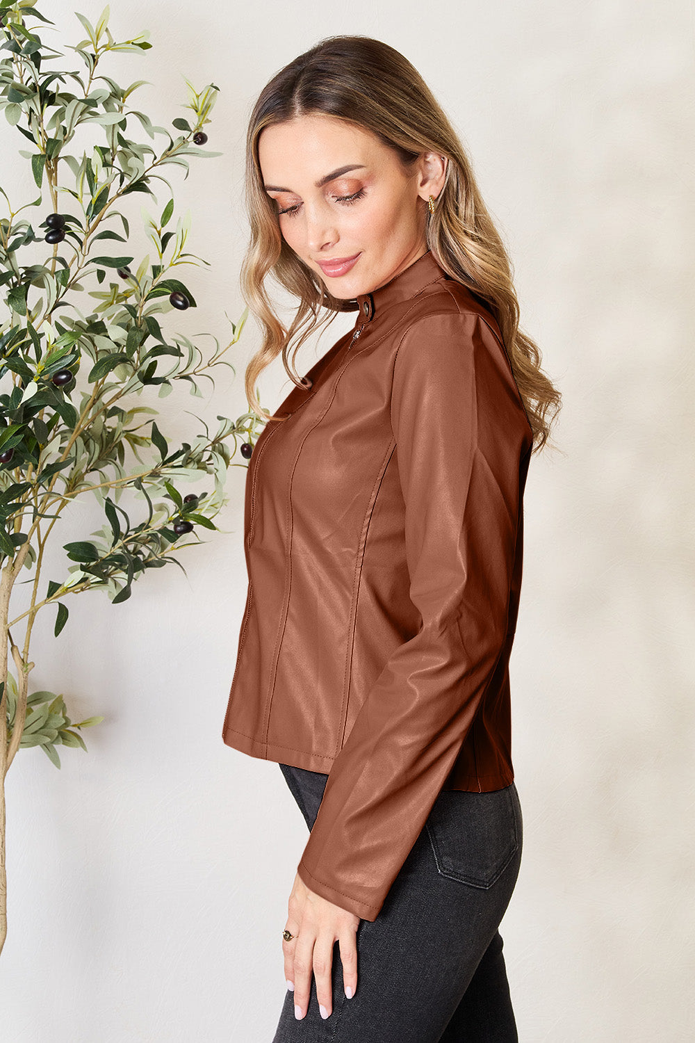 Biker-inspired faux leather jacket in dark camel with a stand-up collar and zip front.