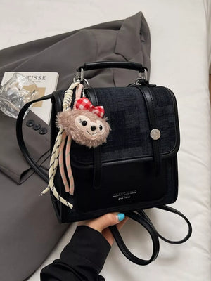 Chic black mini flap backpack with plush charm and red gingham bow detail