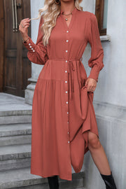 Red orange tiered midi shirt dress with button front, tie waist, and gathered cuffs.