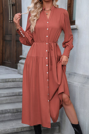 Red orange tiered midi shirt dress with button front, tie waist, and gathered cuffs.