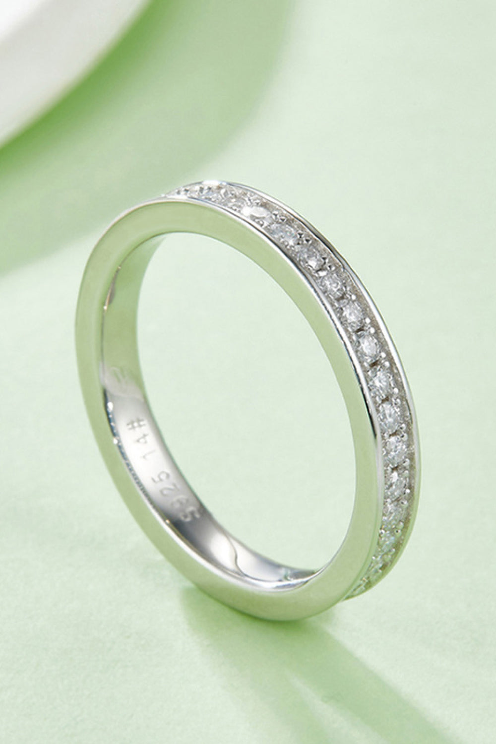 Silver pavé moissanite eternity band ring with 925 sterling silver marking.