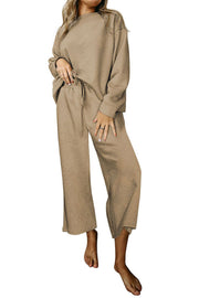 Beige loungewear set with textured pattern, crew neck top and wide leg pants with drawstring waist.