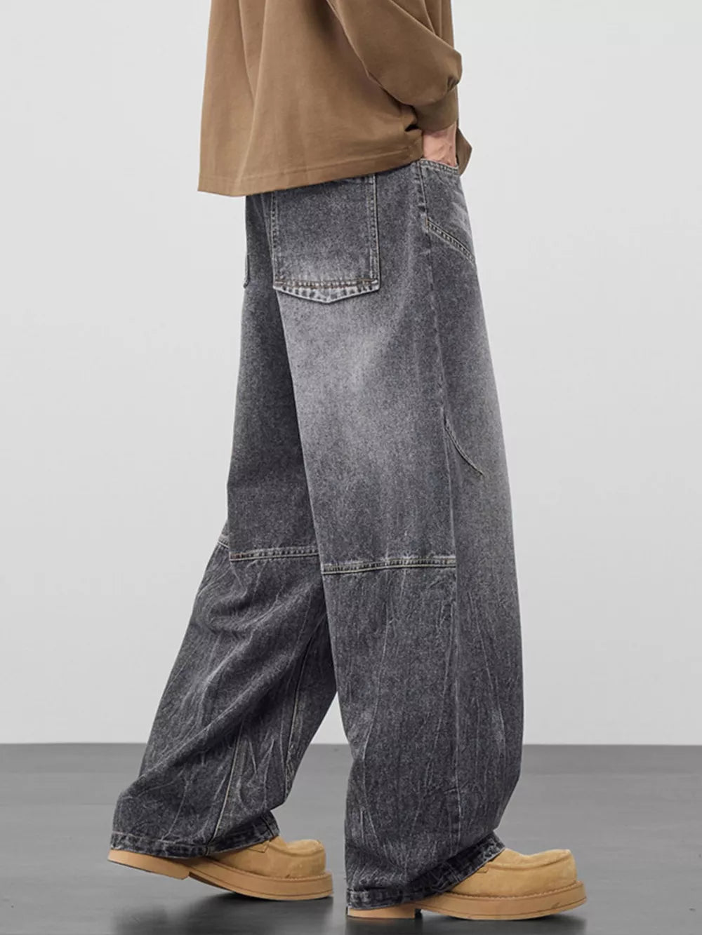 Men's black gray wide-leg jeans with geometric panel detailing and distressed wash.
