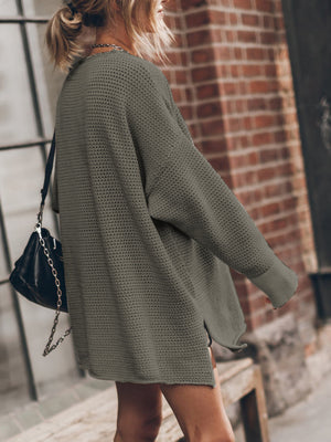 Oversized open-knit sweater dress in army green with side slits, styled casually.
