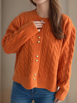 Orange cable knit cardigan with puff sleeves and gold buttons.