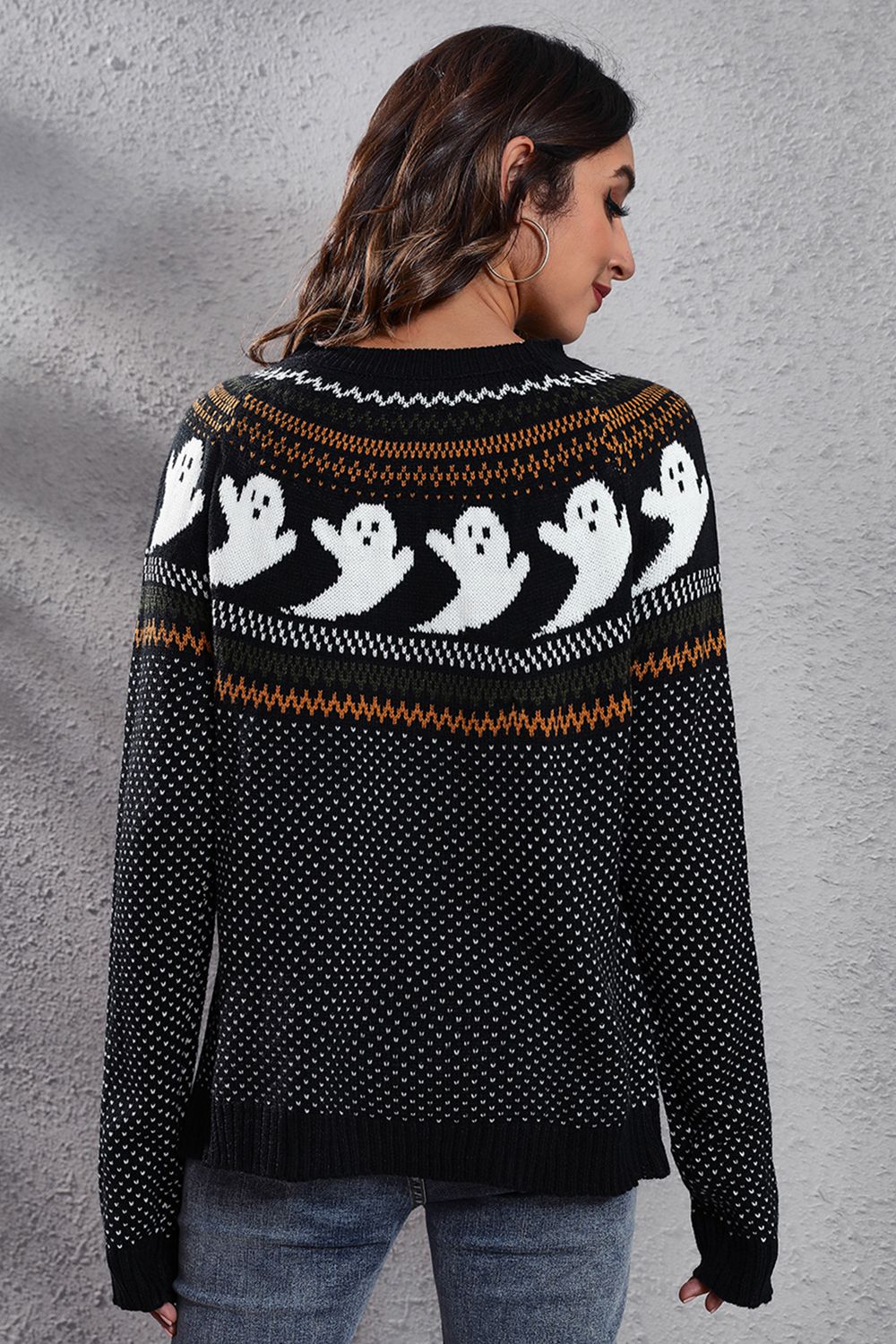Black crewneck sweater with white ghost jacquard pattern and striped yoke.