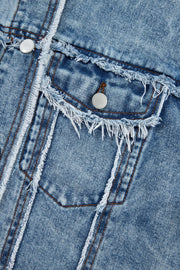 Medium wash denim trucker jacket with distressed details and frayed edges.