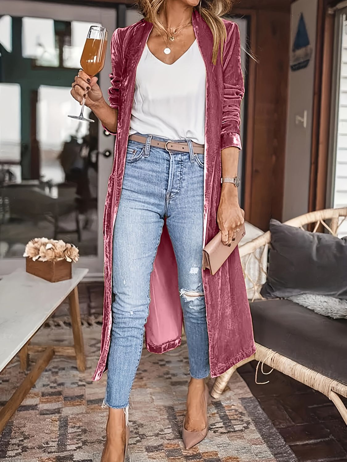 Burgundy velvet duster coat with fluid silhouette, open front, long sleeves, worn with jeans.