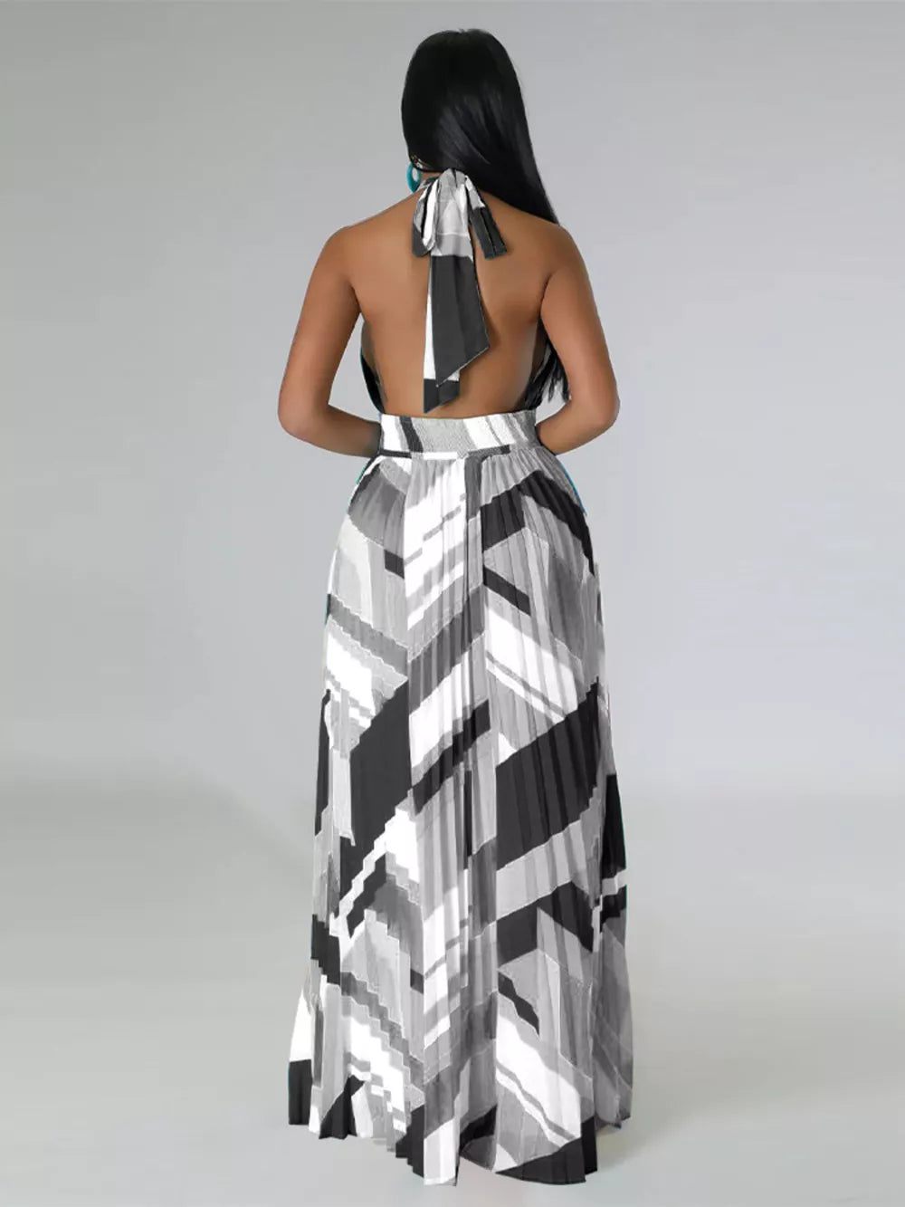 Halter neck maxi dress with geometric print and pleated skirt.