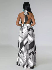 Halter neck maxi dress with geometric print and pleated skirt.