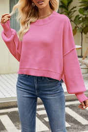 Boxy ribbed knit sweater in hot pink with crew neck and balloon sleeves.