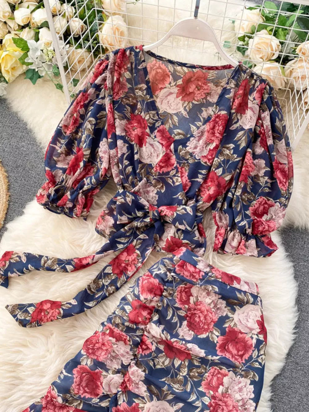 Chic floral two-piece crop set in dark blue with v-neck, puff sleeves, and tie waist.