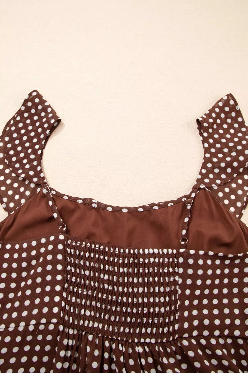 Brown polka dot maxi dress with smocked bodice and ruffled sleeves.