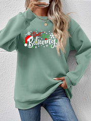 Sage green crewneck sweater with "Don't Stop Believing" graphic and Santa hat detail.