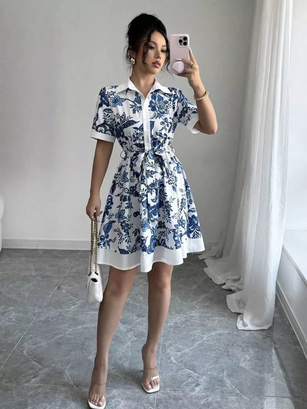 Indigo floral print mini dress with tie belt, collared, short sleeves, and a flared skirt.