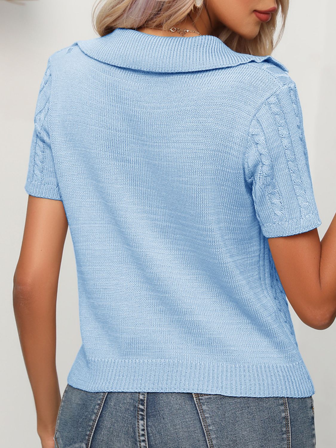 Light blue cable knit short sleeve polo sweater with a collared neckline.