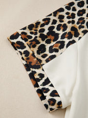 Leopard print buttoned blouse with beige contrast sleeves.