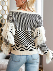 Beige acrylic sweater with geometric pattern and fringe details on sleeves.