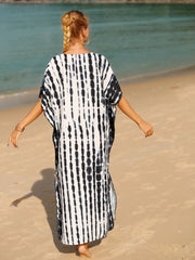Black tie-dye maxi kaftan with vertical stripes and short sleeves, worn on the beach.