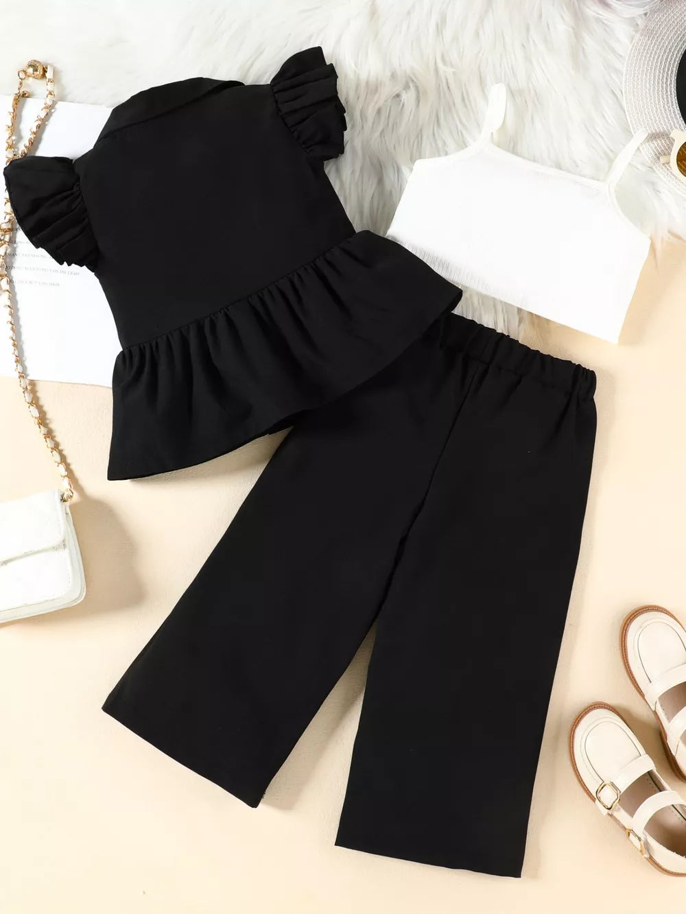 Black toddler ruffle sleeve peplum top and wide-leg pants set with white cami.