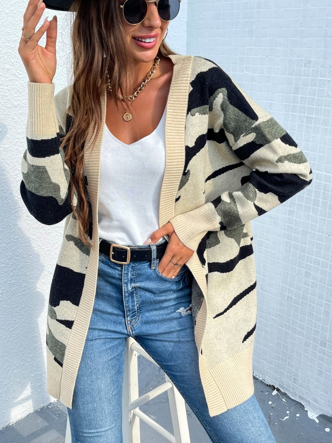 Longline knit cardigan in green camouflage pattern with beige trim and cuffs.