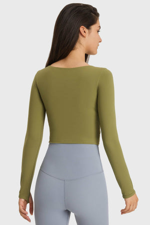 Olive green crop top with thumbhole sleeves and a square neckline.