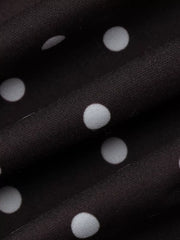 Chic polka dot mini dress in black with white dots, featuring a cut-out detail.