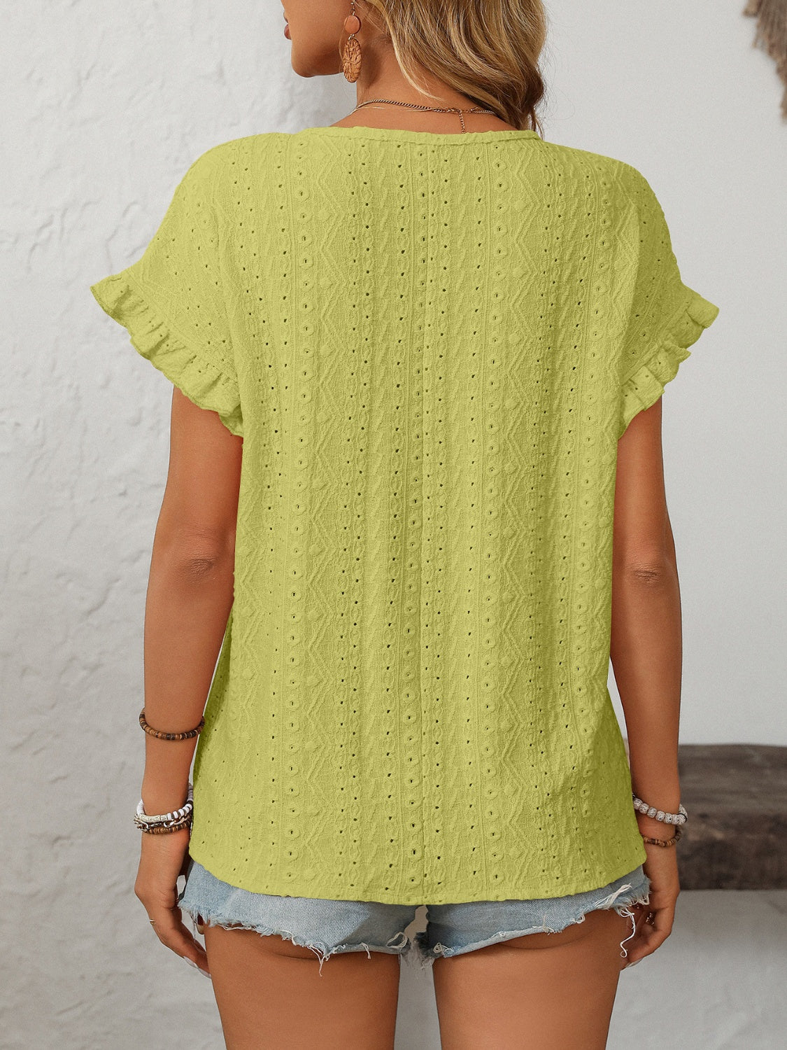 Yellow-green eyelet knit blouse with ruffled short sleeves and textured pattern.