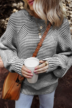 Textured stripe batwing knit sweater in black and gray with a relaxed fit and crew neck.