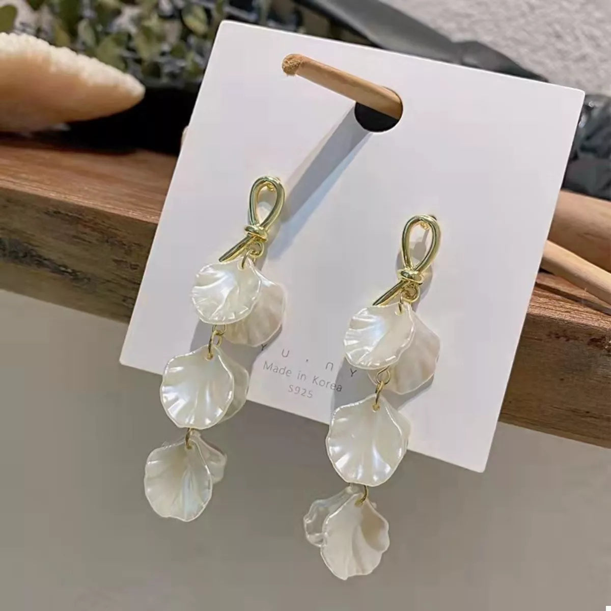 Elegant beige shell drop earrings with gold accents.