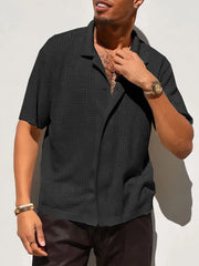 Black perforated knit resort shirt with short sleeves and a spread collar.