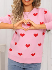 Pink acrylic knit sweater with a red heart print, crew neck, and long sleeves.
