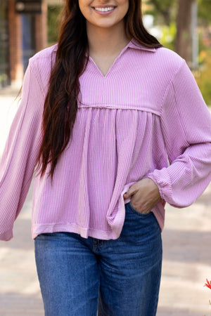Lilac textured blouse with gathered yoke, collar, and long sleeves.