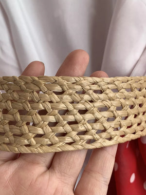 Woven straw belt detail on a red polka dot dress