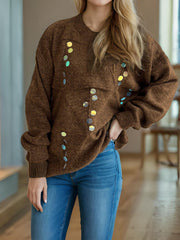 Brown knit sweater with round sequin embellishments and a crew neck.